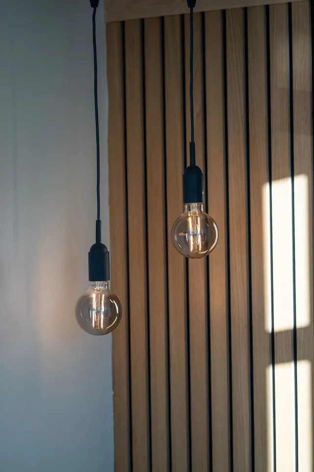 Pendant lamps against the slatted timber wall