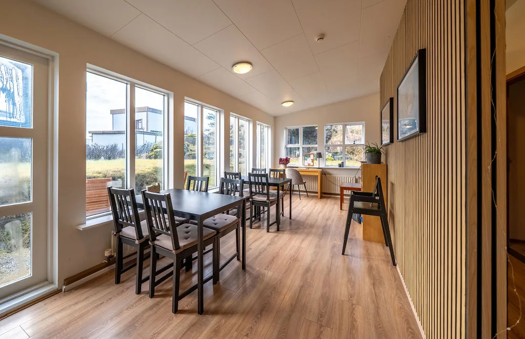 The shared dining room with a long row of windows over Höfn