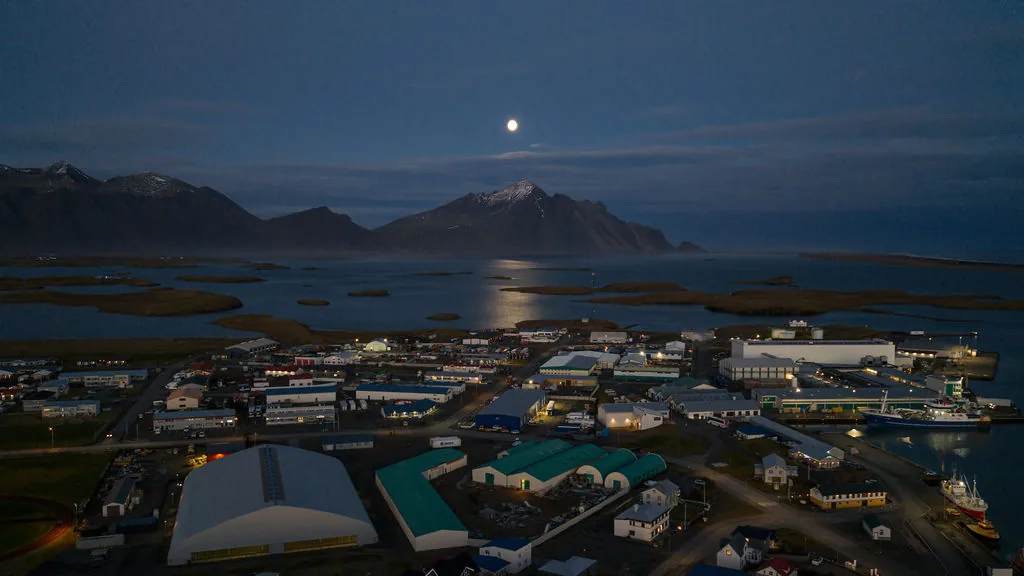 Höfn í Hornafirði from the air at dusk, with the fjord and the mountains behind
